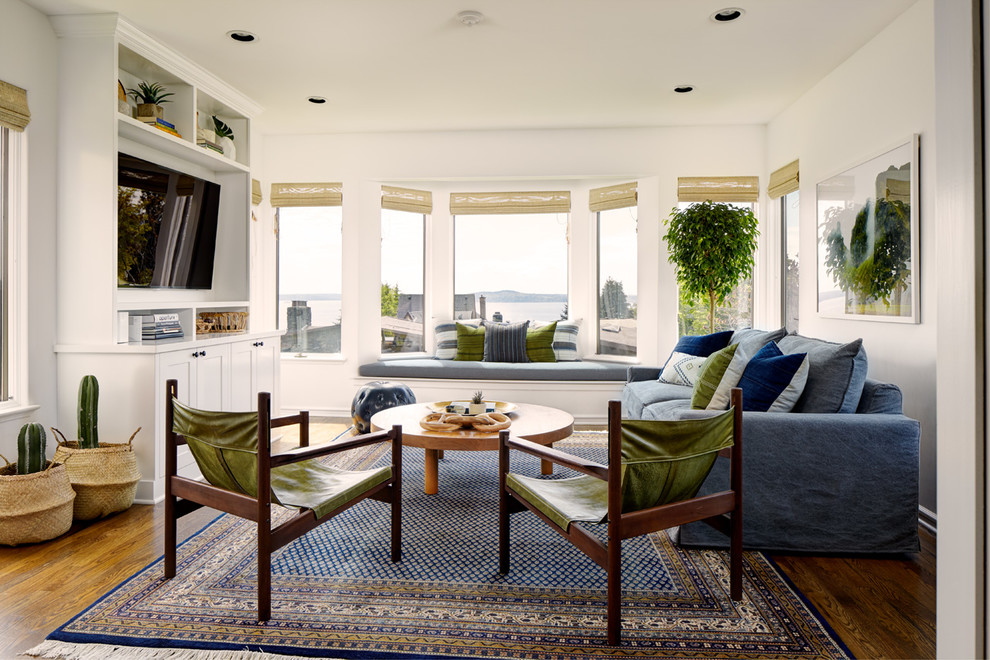 Inspiration for a beach style family room in Seattle with white walls, dark hardwood floors, a built-in media wall and brown floor.