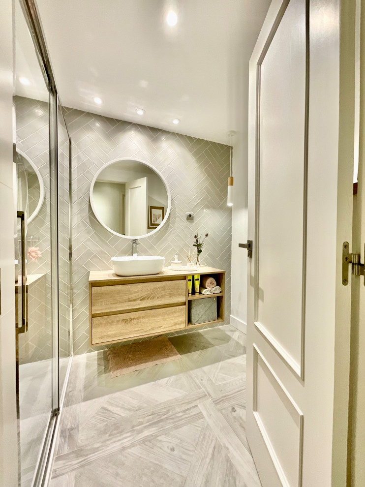 Idéer för att renovera ett mellanstort funkis beige beige badrum, med släta luckor, vita skåp, en vägghängd toalettstol, grå kakel, keramikplattor, vita väggar, klinkergolv i porslin, ett fristående handfat, laminatbänkskiva, grått golv och dusch med skjutdörr