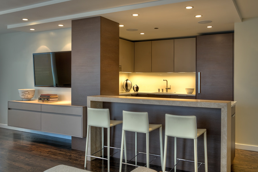 Design ideas for a small modern u-shaped open plan kitchen in Chicago with an undermount sink, flat-panel cabinets, dark wood cabinets, limestone benchtops, white splashback, stainless steel appliances, medium hardwood floors, a peninsula and brown floor.