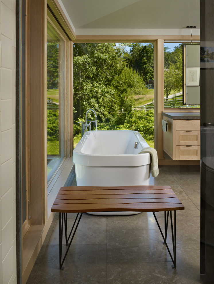 Inspiration for a small contemporary master bathroom in Seattle with a freestanding tub, an undermount sink, shaker cabinets, light wood cabinets, limestone benchtops, a curbless shower, a one-piece toilet, porcelain tile and porcelain floors.