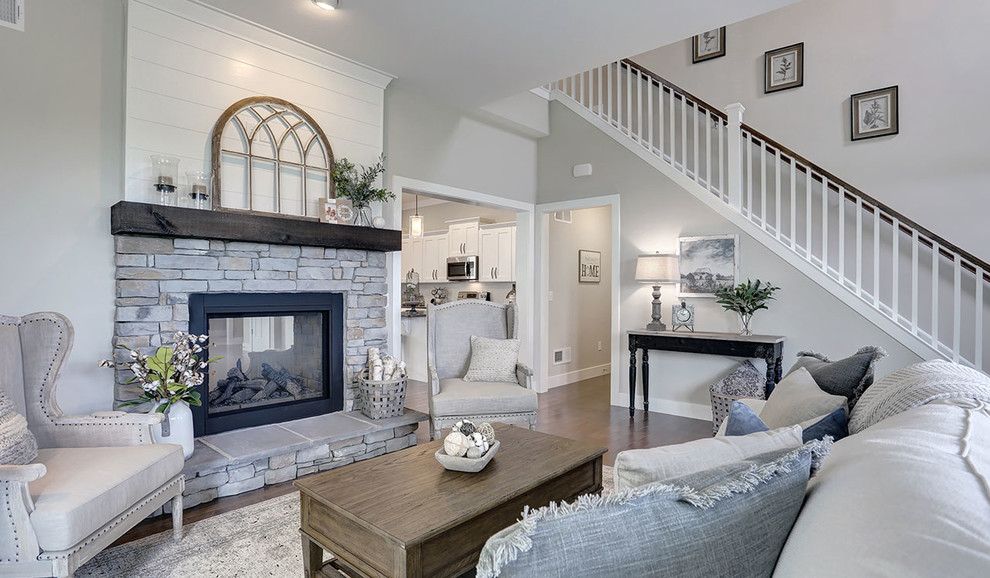 Mid-sized country open concept family room in Other with grey walls, dark hardwood floors, a two-sided fireplace and a stone fireplace surround.