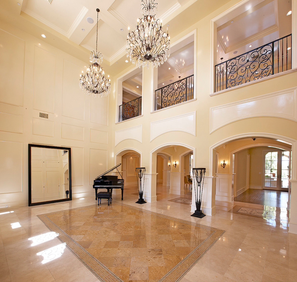 This is an example of a large mediterranean foyer in Orange County with beige walls, ceramic floors, a double front door, a glass front door and beige floor.