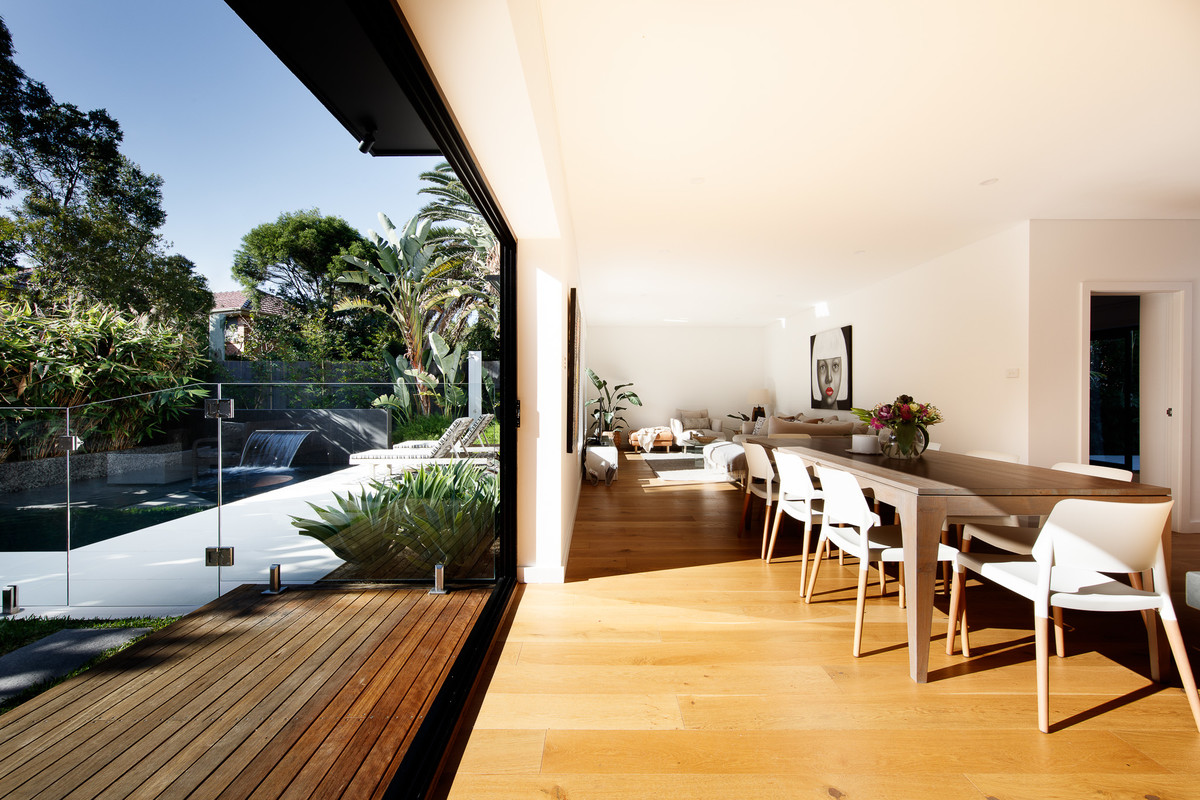 This is an example of a mid-sized contemporary dining room in Sydney with white walls and medium hardwood floors.