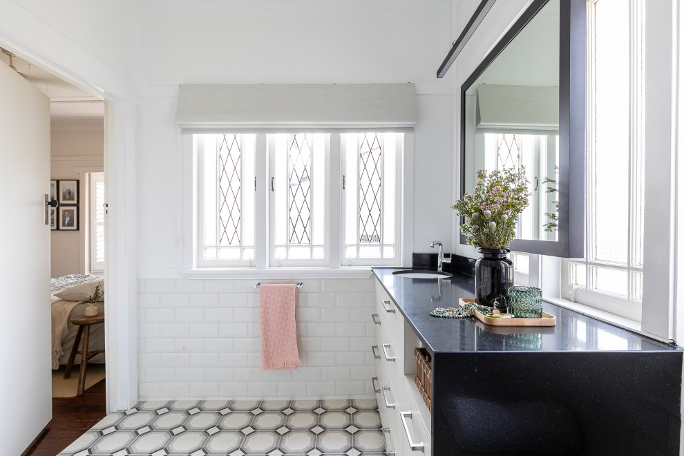 This is an example of a mid-sized midcentury master bathroom in Brisbane with flat-panel cabinets, beige cabinets, a curbless shower, beige tile, white walls, an undermount sink, engineered quartz benchtops, an open shower, black benchtops, a shower seat, a single vanity and a built-in vanity.