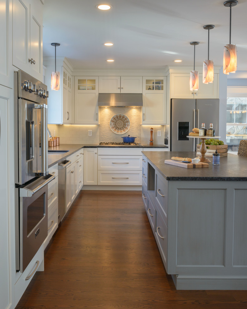 Photo of a mid-sized transitional l-shaped eat-in kitchen in Boston with white cabinets, stainless steel appliances, medium hardwood floors, with island, an undermount sink, shaker cabinets, granite benchtops and brown floor.