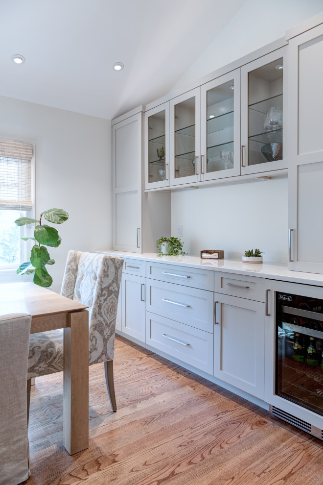 Mittelgroße Moderne Wohnküche mit weißer Wandfarbe, braunem Holzboden, Kamin, Kaminumrandung aus Stein, braunem Boden und gewölbter Decke in Washington, D.C.