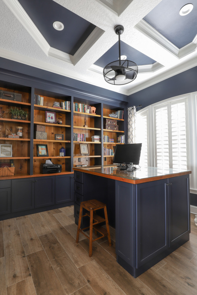 Mid-sized country home office in Jacksonville with blue walls, porcelain floors, a freestanding desk, brown floor and coffered.