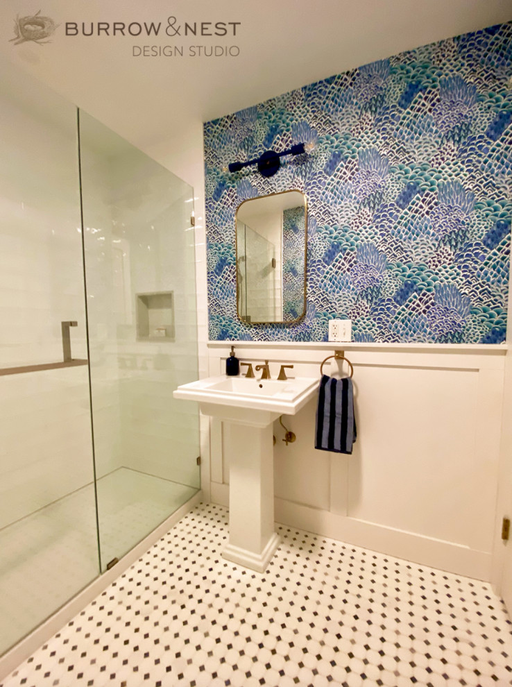 Inredning av ett lantligt badrum, med en bidé, vit kakel, keramikplattor, blå väggar, marmorgolv, ett piedestal handfat och blått golv