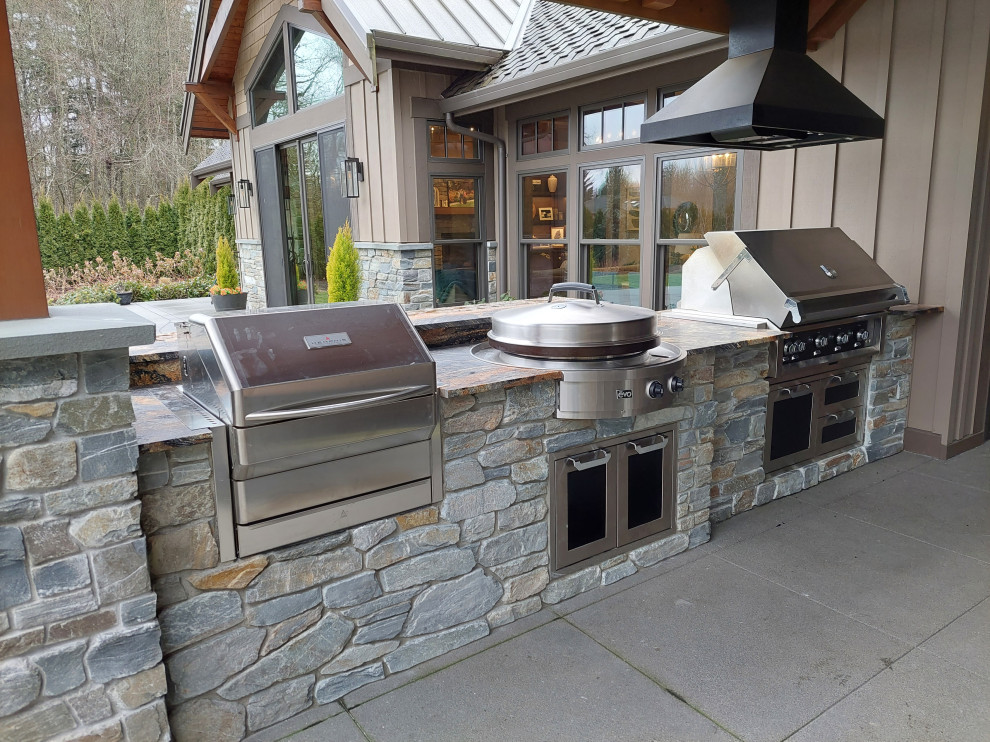 This is an example of a medium sized traditional back patio in Seattle with an outdoor kitchen, concrete paving and a roof extension.