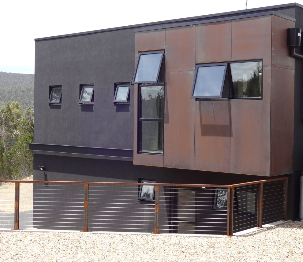 This is an example of a large industrial two-storey black house exterior in Other with a flat roof and a metal roof.