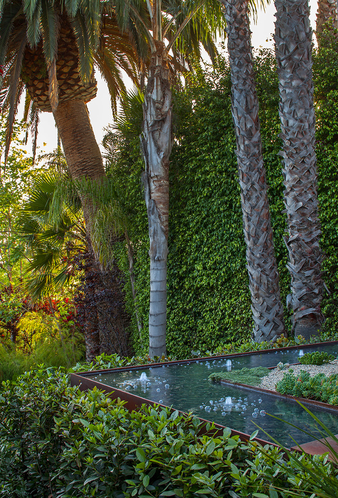 Contemporary backyard formal garden in Los Angeles with a water feature and gravel.