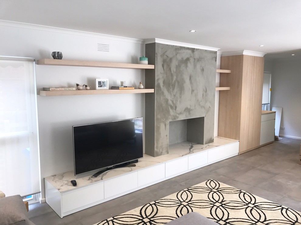 Inspiration for a mid-sized modern formal open concept living room in Melbourne with white walls, slate floors, a wood stove, a concrete fireplace surround, a freestanding tv and grey floor.