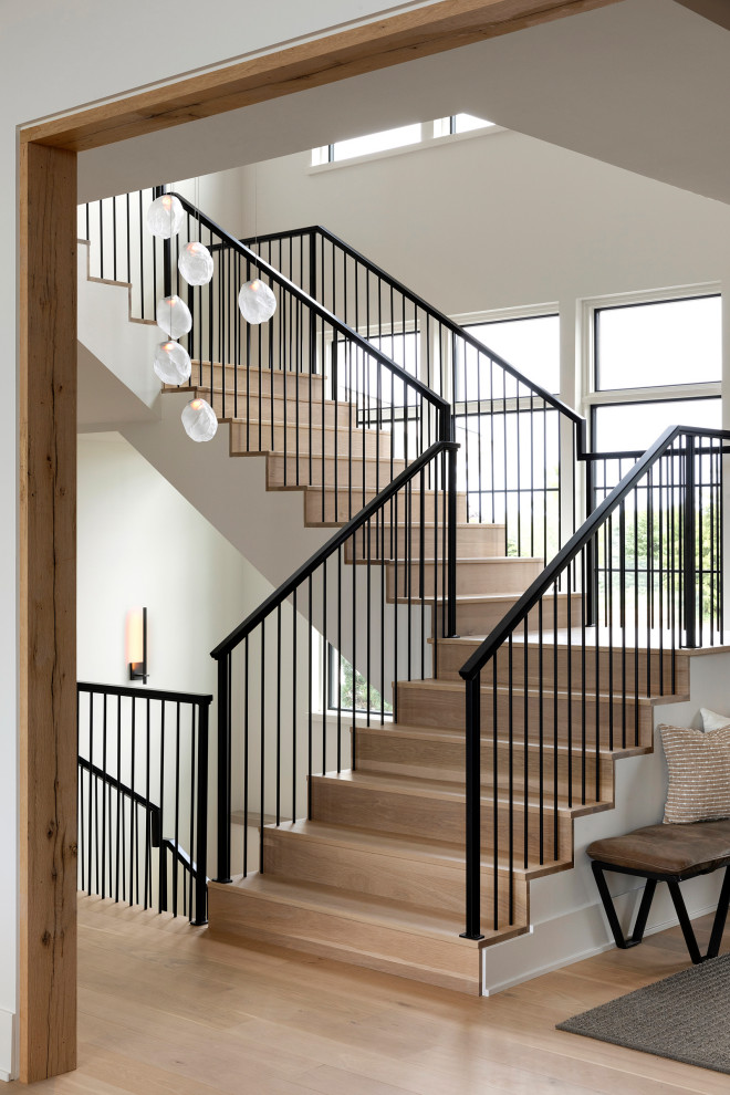Photo of a large traditional metal railing staircase in Minneapolis with wood risers.