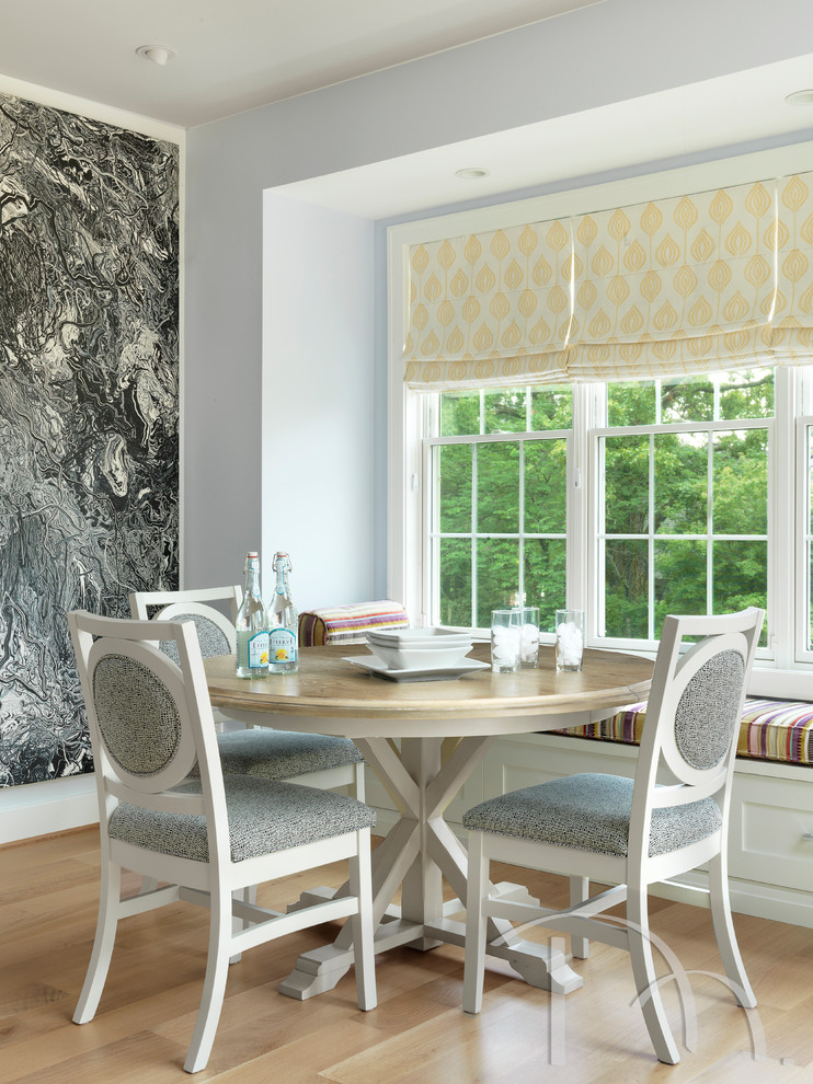 Example of a mid-sized transitional light wood floor kitchen/dining room combo design with an undermount sink, shaker cabinets, blue cabinets, solid surface countertops, white backsplash, glass tile backsplash, stainless steel appliances and an island