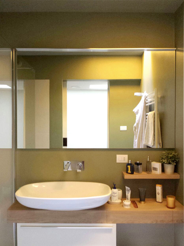 Inspiration for a small contemporary 3/4 bathroom in Other with flat-panel cabinets, white cabinets, a curbless shower, a wall-mount toilet, green tile, ceramic tile, green walls, ceramic floors, a vessel sink, wood benchtops, green floor, a hinged shower door and brown benchtops.