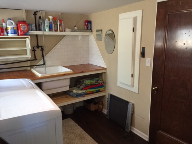 Mid-sized country l-shaped utility room in Chicago with an utility sink, beige walls, vinyl floors and a side-by-side washer and dryer.