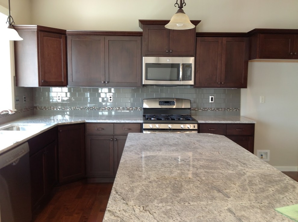 Example of a mid-sized transitional l-shaped dark wood floor eat-in kitchen design with an undermount sink, dark wood cabinets, granite countertops, ceramic backsplash, stainless steel appliances, an island, shaker cabinets and gray backsplash