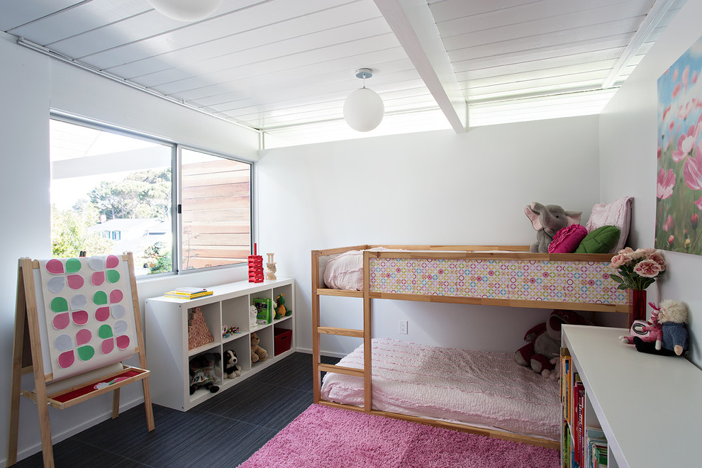 Design ideas for a midcentury kids' bedroom for girls in San Francisco with white walls and black floor.