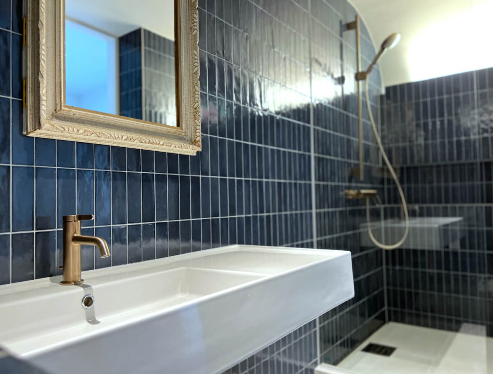 Ispirazione per un bagno di servizio minimalista con ante bianche, WC monopezzo, piastrelle blu, piastrelle in gres porcellanato, pavimento bianco, top bianco e mobile bagno sospeso