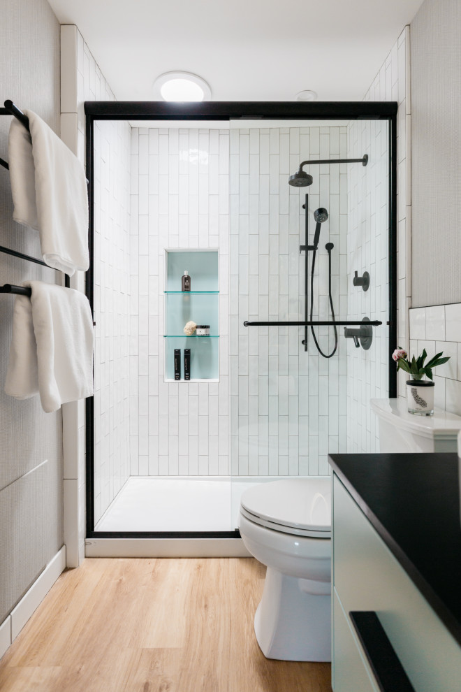 Design ideas for a small contemporary 3/4 bathroom in Los Angeles with flat-panel cabinets, turquoise cabinets, an alcove shower, a two-piece toilet, white tile, porcelain tile, white walls, vinyl floors, a vessel sink, granite benchtops, a sliding shower screen, black benchtops, a niche, a single vanity, a floating vanity and wallpaper.