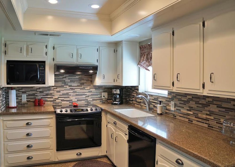 Inspiration for a mid-sized transitional kitchen remodel with an undermount sink, white cabinets, terrazzo countertops, multicolored backsplash, matchstick tile backsplash and black appliances