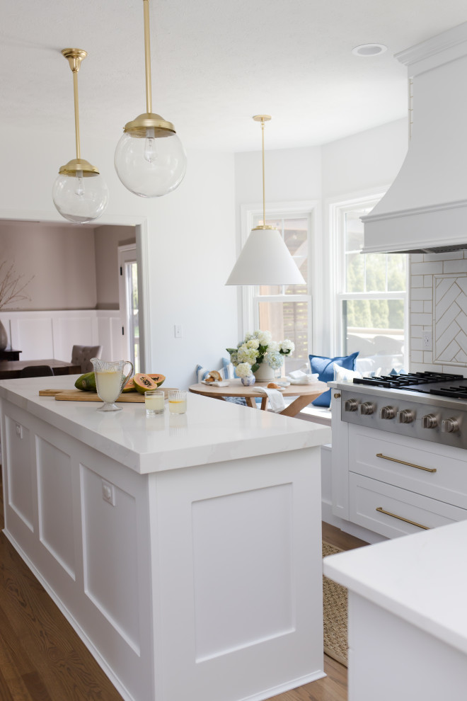 Photo of a traditional kitchen in Other with a submerged sink, white cabinets, marble worktops, white splashback, ceramic splashback, stainless steel appliances, an island and white worktops.