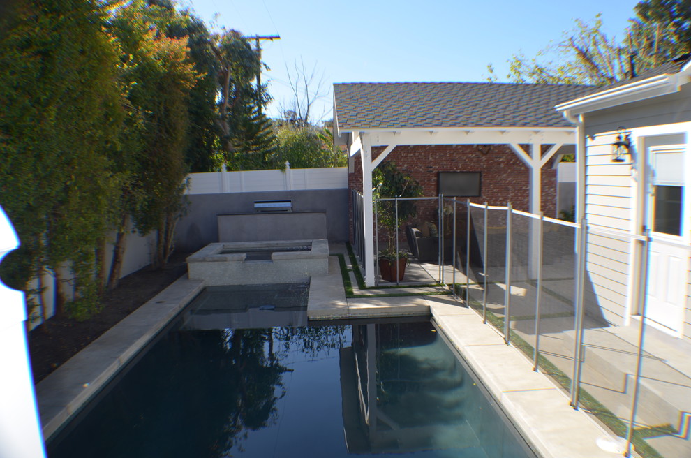 Inspiration for a mid-sized traditional backyard rectangular natural pool in Los Angeles with a hot tub and concrete slab.