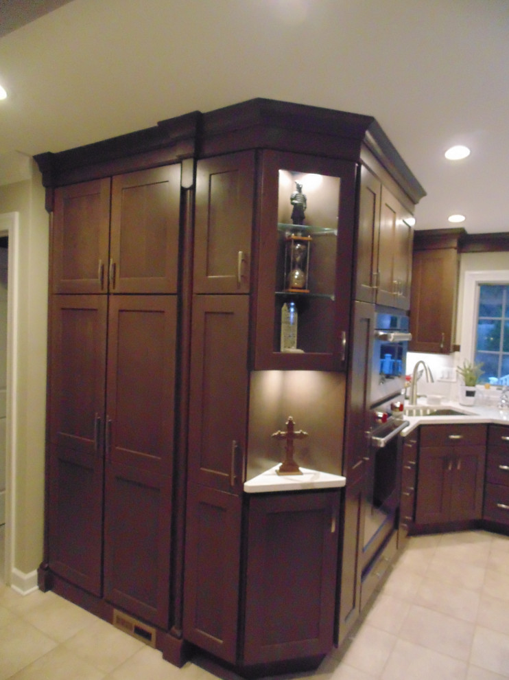 Mid-sized transitional u-shaped ceramic tile and beige floor eat-in kitchen photo with an undermount sink, recessed-panel cabinets, dark wood cabinets, quartz countertops, white backsplash, stone slab backsplash, stainless steel appliances, an island and white countertops
