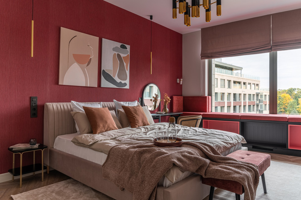 Foto de dormitorio actual de tamaño medio con paredes rojas, suelo de madera en tonos medios, suelo beige y papel pintado