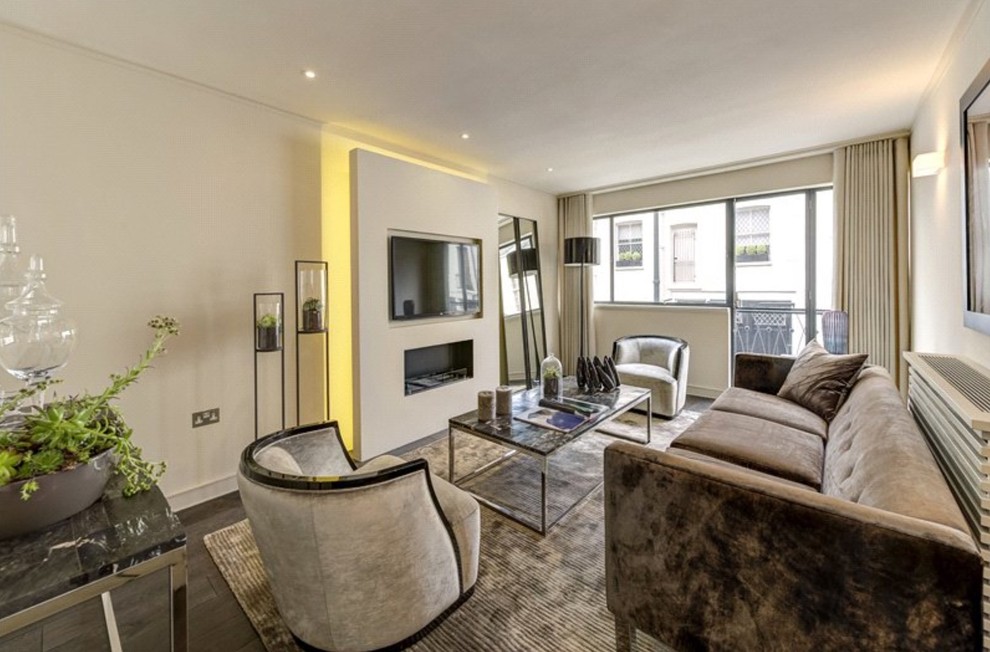 This is an example of a small transitional living room in London with white walls, a ribbon fireplace, a built-in media wall, dark hardwood floors and brown floor.