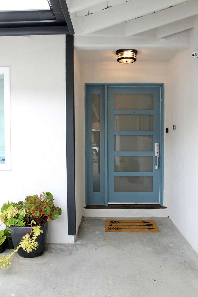 This is an example of a small modern front door in Los Angeles with blue walls, light hardwood floors, a single front door, a blue front door and beige floor.
