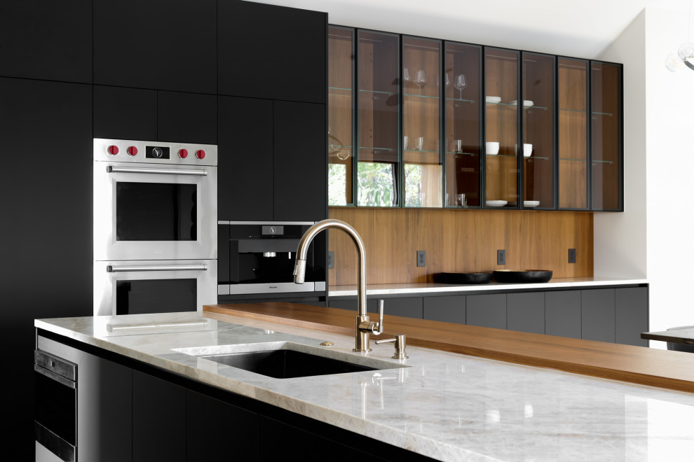 Idéer för att renovera ett stort funkis vit vitt kök, med en nedsänkt diskho, släta luckor, svarta skåp, marmorbänkskiva, vitt stänkskydd, stänkskydd i marmor, rostfria vitvaror, mellanmörkt trägolv, en köksö och brunt golv