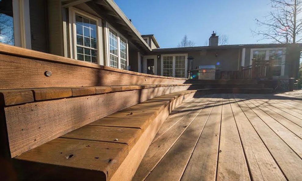 This is an example of a mid-sized modern backyard patio in Sacramento with decking and no cover.