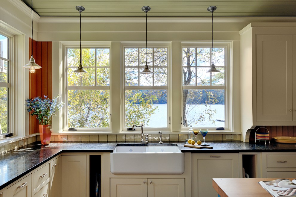 Inspiration for a country kitchen in Burlington with a farmhouse sink, beaded inset cabinets and beige cabinets.