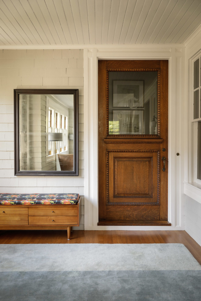 Photo of a transitional front door in Portland Maine with white walls, dark hardwood floors, a single front door, a dark wood front door, beige floor, timber and wood walls.