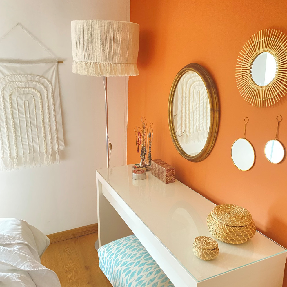 Imagen de dormitorio principal retro pequeño con parades naranjas, suelo de madera en tonos medios y suelo marrón