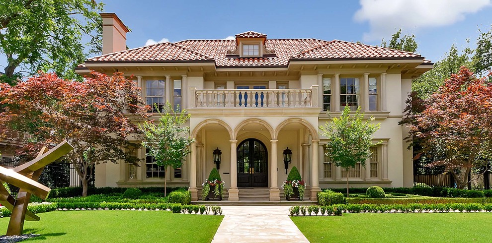Inspiration for a mediterranean two-storey stucco beige exterior in Dallas with a hip roof.