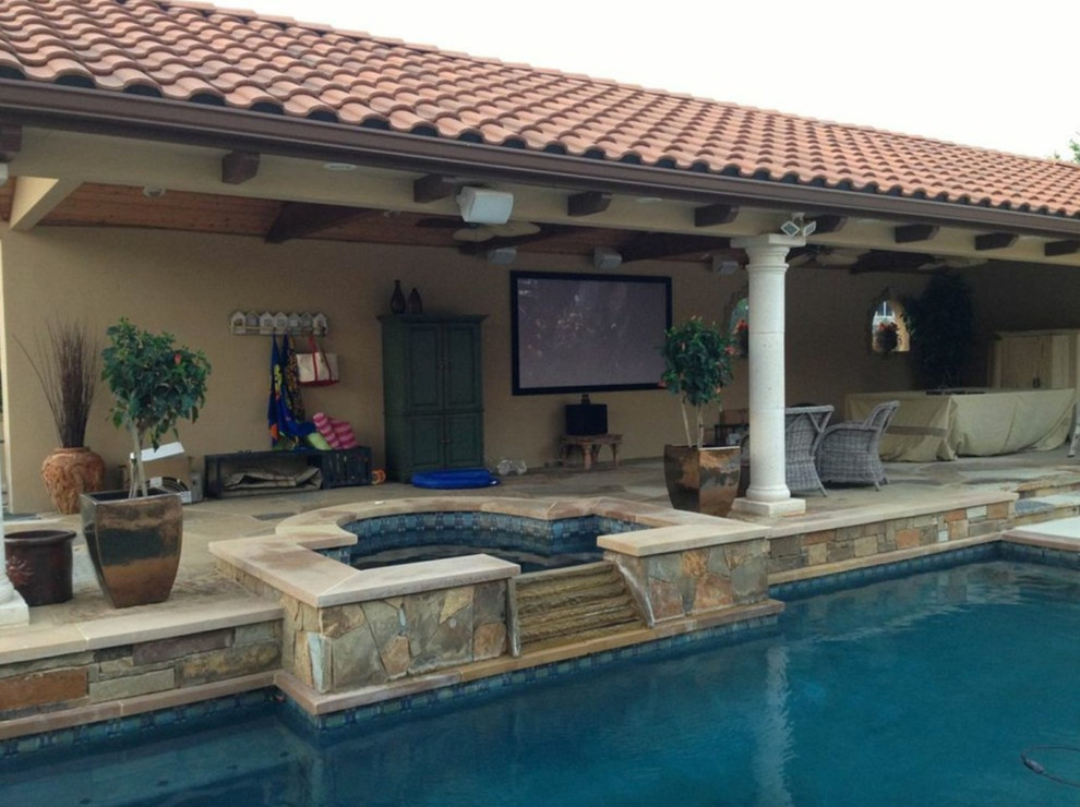 Patio - large transitional backyard stone patio idea in Orange County with a roof extension