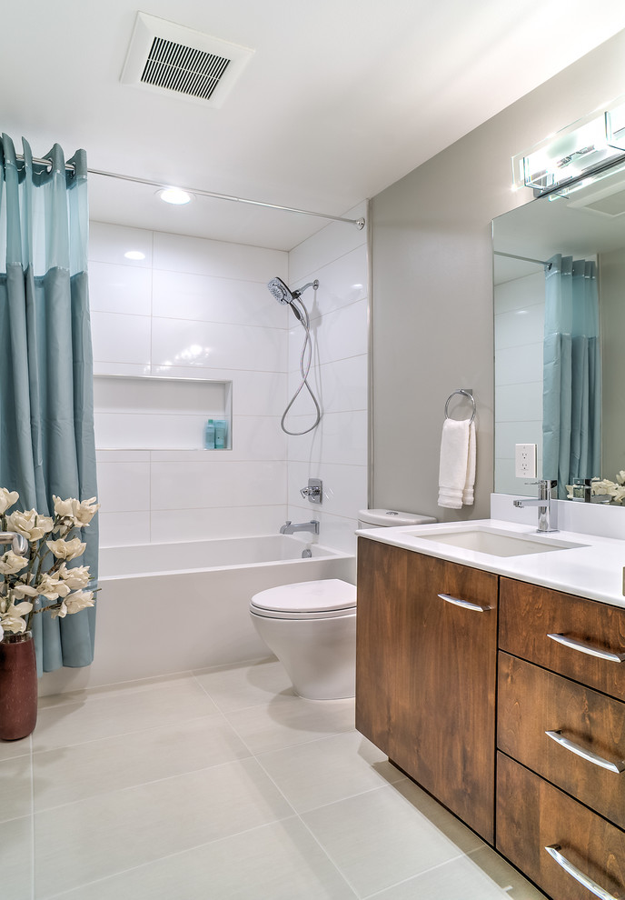 Inspiration for a mid-sized modern bathroom in San Francisco with an undermount sink, flat-panel cabinets, dark wood cabinets, engineered quartz benchtops, an alcove tub, a shower/bathtub combo, a two-piece toilet, white tile, porcelain tile, grey walls, porcelain floors, white floor and a shower curtain.