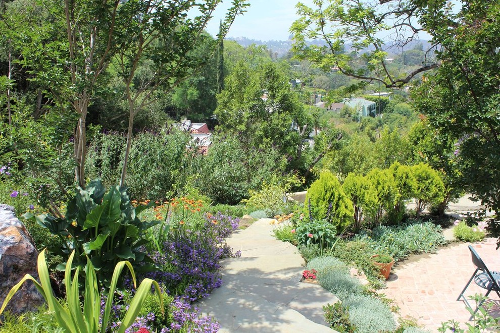 Photo of a mid-sized traditional backyard partial sun garden in Los Angeles with a garden path and natural stone pavers.