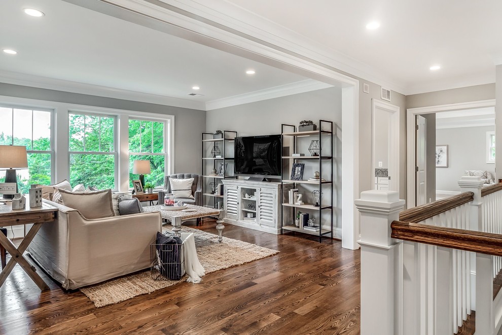 Inspiration for a large arts and crafts open concept family room in DC Metro with grey walls, dark hardwood floors, no fireplace, a freestanding tv and brown floor.
