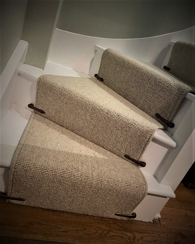 Modelo de escalera curva minimalista de tamaño medio con escalones enmoquetados, contrahuellas enmoquetadas y barandilla de madera