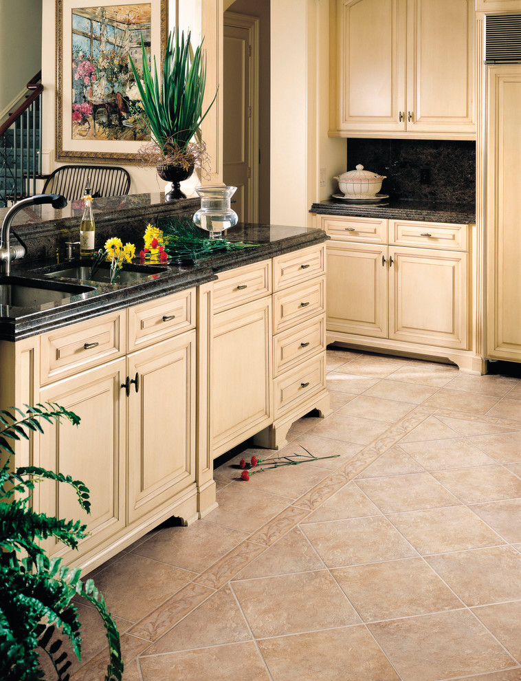 Kitchen - transitional porcelain tile kitchen idea in Miami with raised-panel cabinets, yellow cabinets, granite countertops and black backsplash
