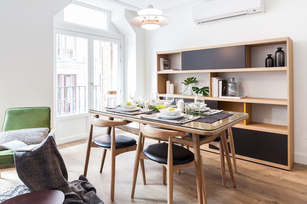 This is an example of a mid-sized contemporary open plan dining in Madrid with white walls, medium hardwood floors, no fireplace and brown floor.