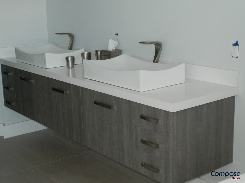 This is an example of a mid-sized modern bathroom in Miami with a vessel sink, flat-panel cabinets, dark wood cabinets, solid surface benchtops, white tile, white walls and porcelain floors.