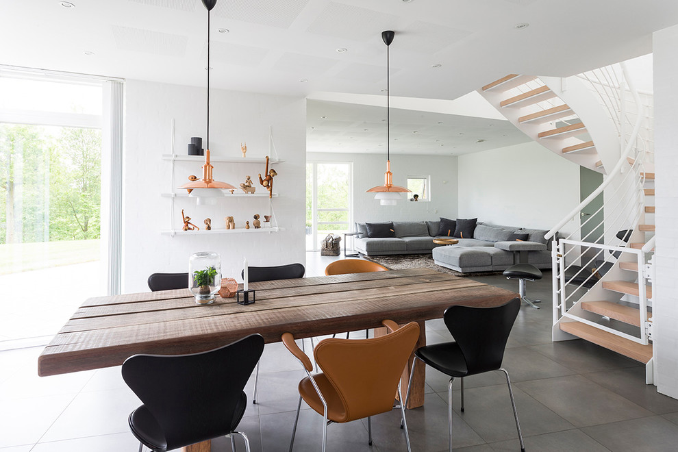 Photo of a mid-sized contemporary open plan dining in Other with white walls and grey floor.
