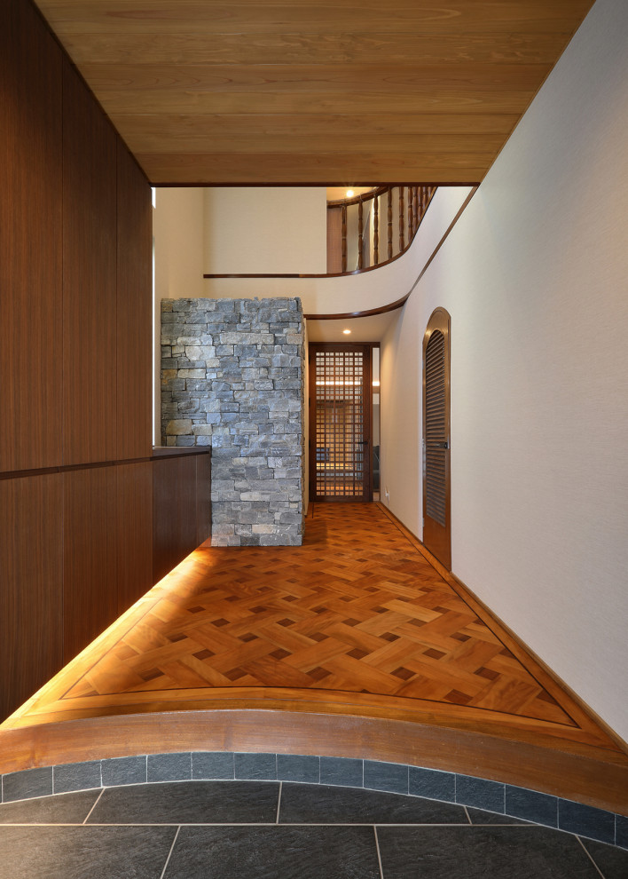 Foto di un grande corridoio con pareti beige, pavimento in legno verniciato, una porta singola, una porta in legno scuro, pavimento multicolore e soffitto in legno