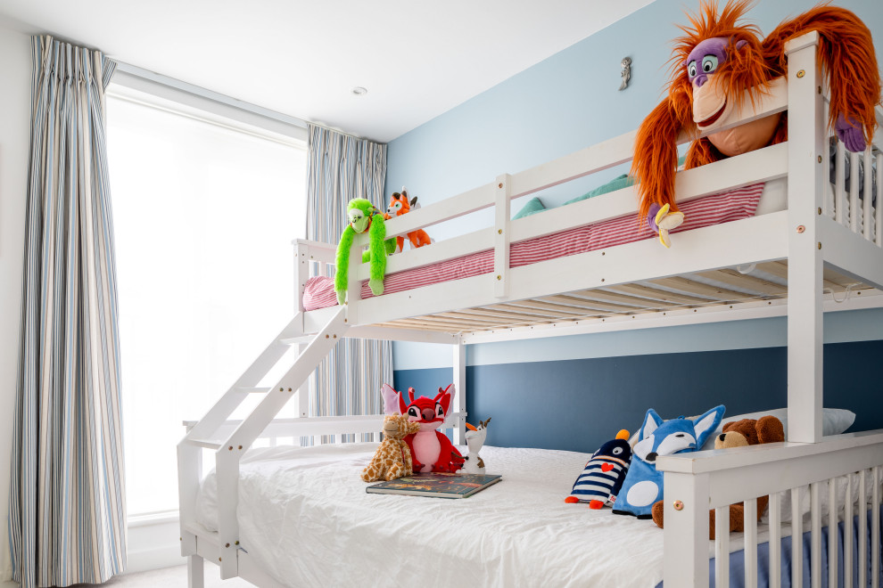Inspiration for a small modern kids' bedroom for boys in London with blue walls, carpet and beige floors.
