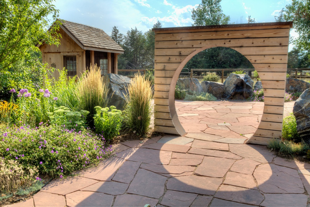 Inspiration for a huge farmhouse drought-tolerant backyard stone gate in Denver.