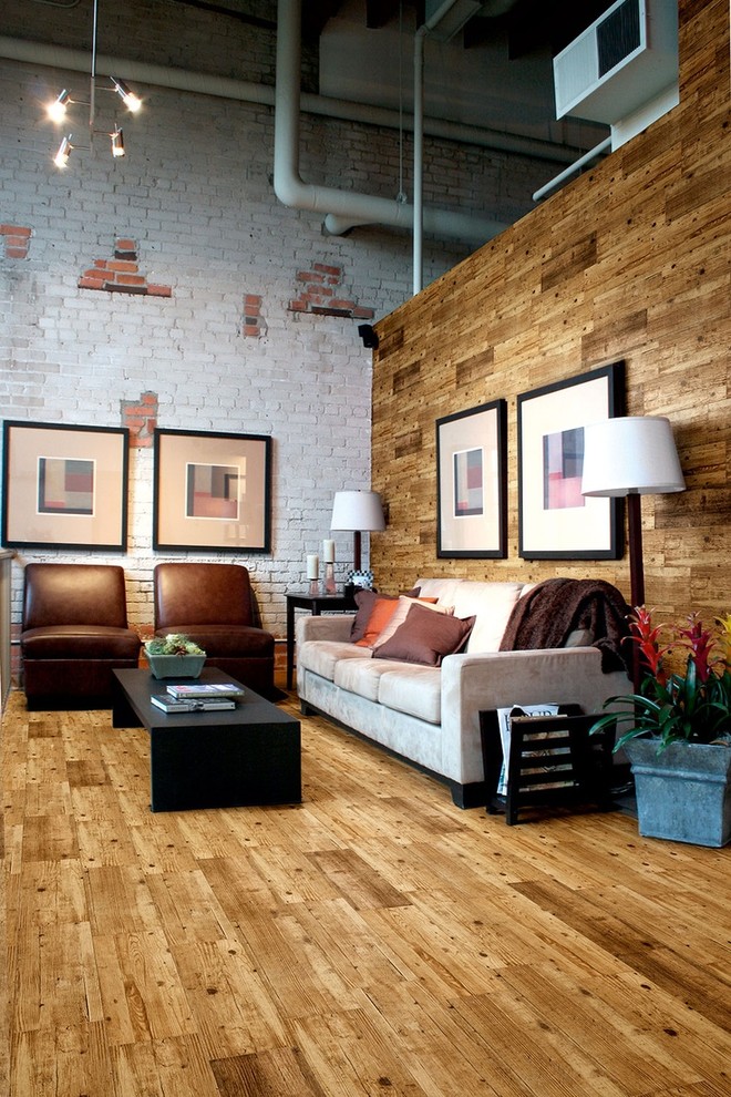 Photo of a mid-sized industrial open concept living room in London with white walls and medium hardwood floors.